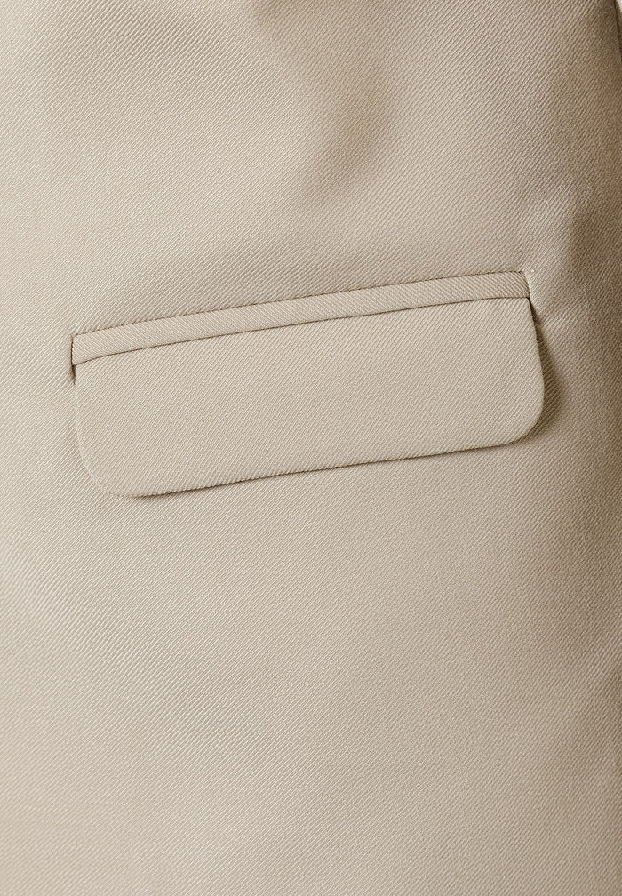 Detail of a boys formal blazer in stone color with a pocket.