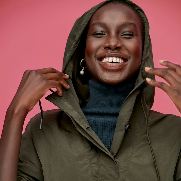 Detail image of a woman standing wearing the Britt Hoodie—AirTech in Dark Moss