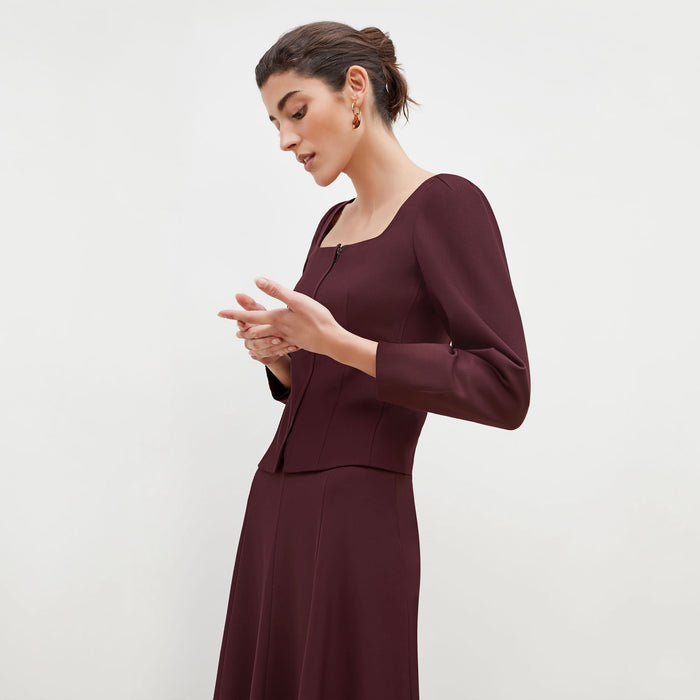 Side image of a woman standing wearing the Dawn Top-Sharkskin in garnet