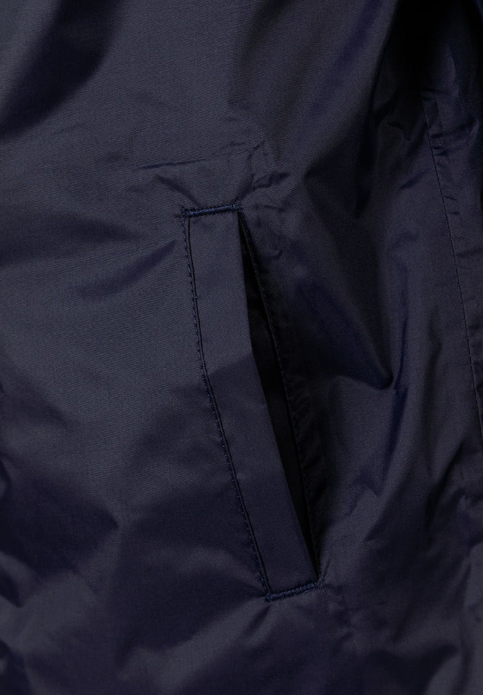 Detail of a navy waterproof jacket showing a side pocket.