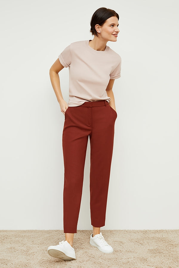 Front image of a woman standing wearing the mejia pant in sharkskin in rust | Grid | Exclude