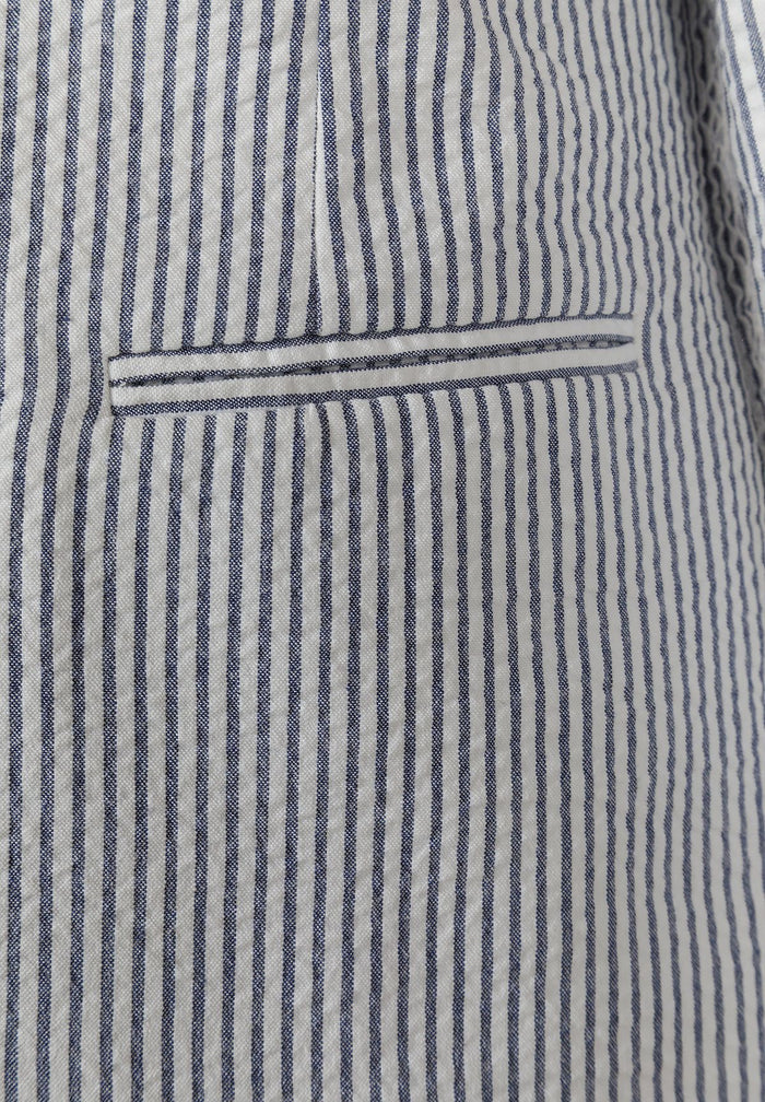 Detail of a boys' navy blue striped tailored blazer with a functional pocket.