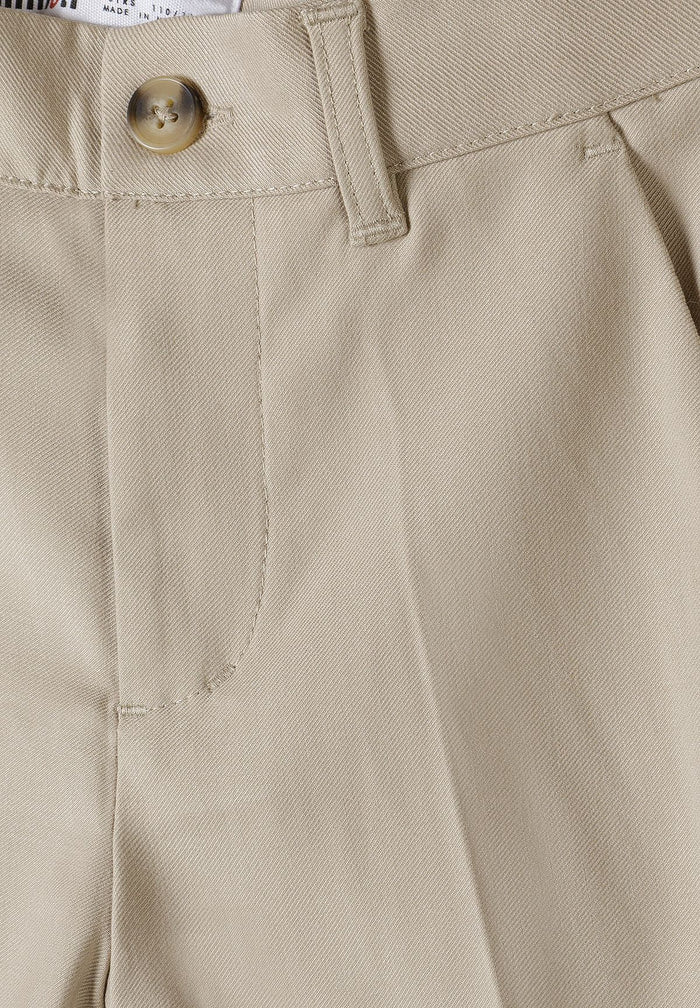 Detail of boys formal trousers in stone color with adjustable waistband and side pocket.