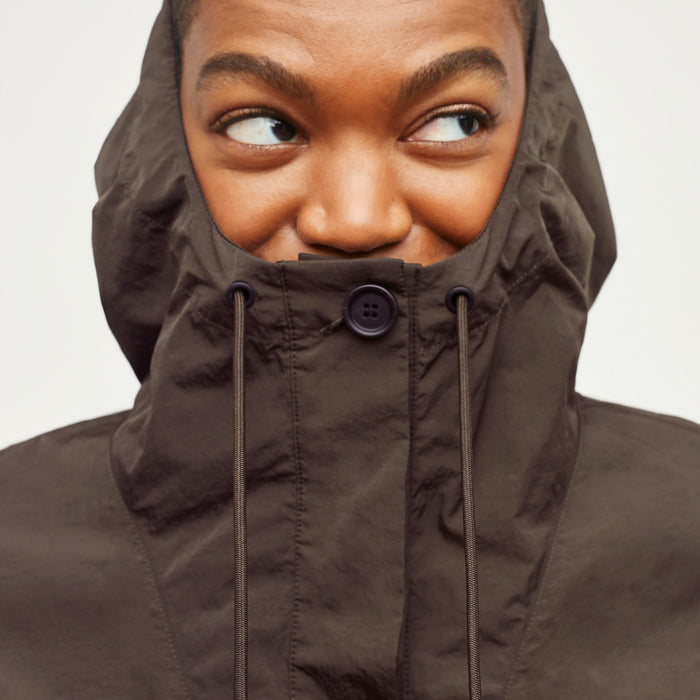 Detail image of a woman standing wearing the Britt Hoodie—AirTech in Dark Moss