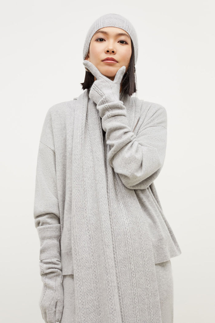 Front image of a woman standing wearing the Circle Cable Scarf—Cashmere in Heather Gray | Grid Hover | Exclude