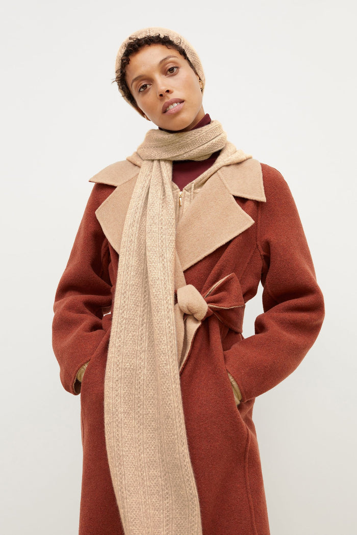 Front image of a woman standing wearing the Circle Cable Scarf—Cashmere in Light Camel | Grid Hover | Exclude
