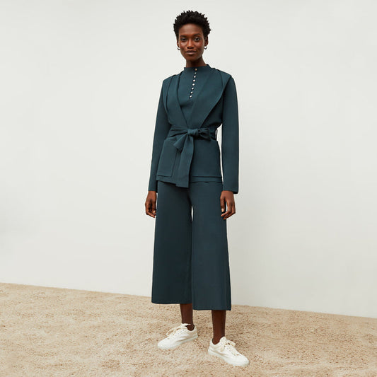 Front image of a woman standing wearing the colette jardigan in deep sea | Lead