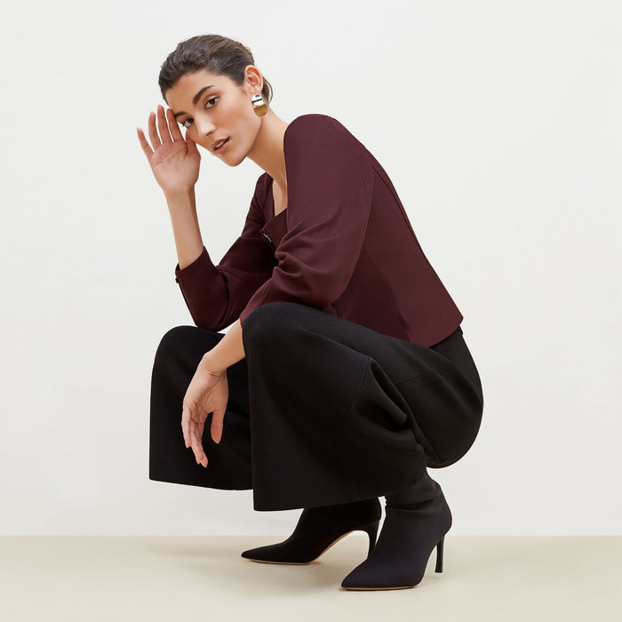 Side image of a woman standing wearing the Dawn Top-Sharkskin in garnet