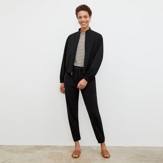 Front image of a woman standing wearing the Delaney Jogger—OrigamiTech in Black | Lead