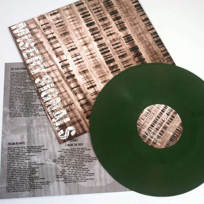 A green Limited Edition vinyl record by Misery Signals, along with an album cover displaying the bands name and an insert featuring printed lyrics and credits, are displayed on a white surface.