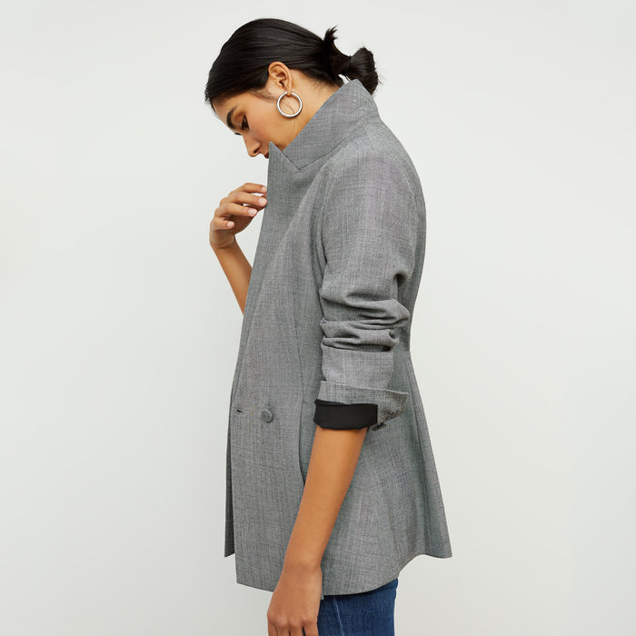Side image of a woman standing wearing the gaia jacket in sharkskin in black and white