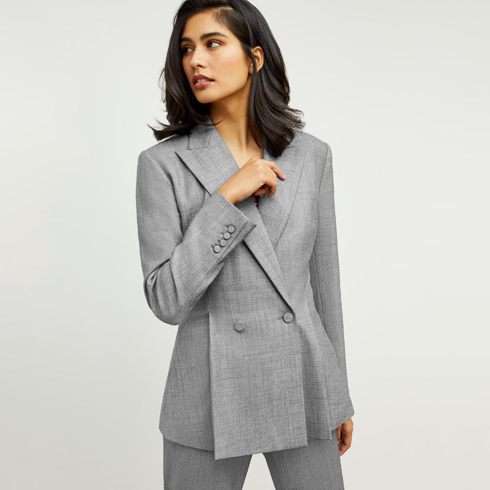 Front image of a woman standing wearing the gaia jacket in sharkskin in black and white
