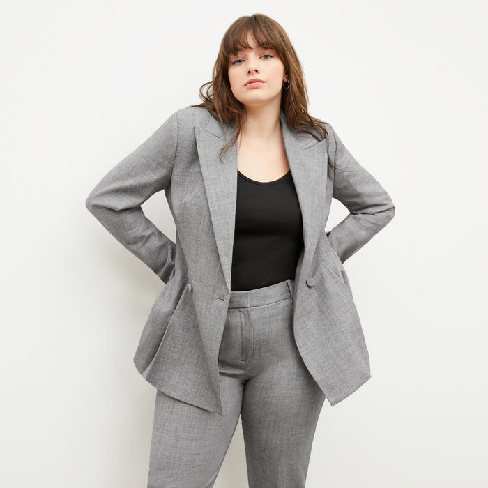 Front image of a woman standing wearing the gaia jacket in sharkskin in black and white