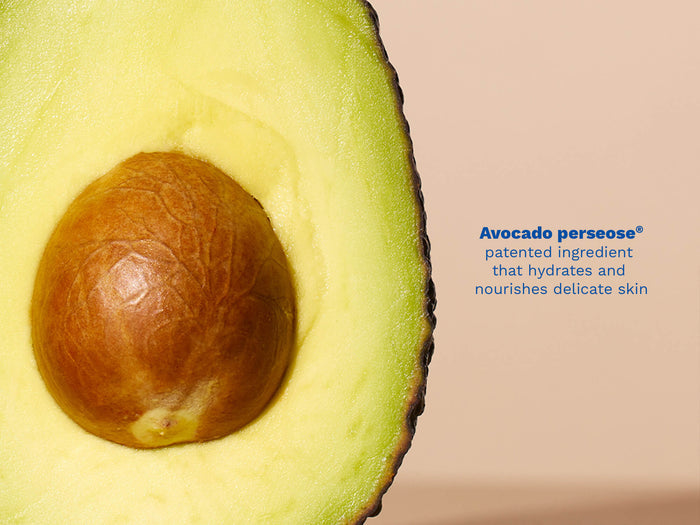 Mustela USA | Close-up of a halved avocado on a beige background.