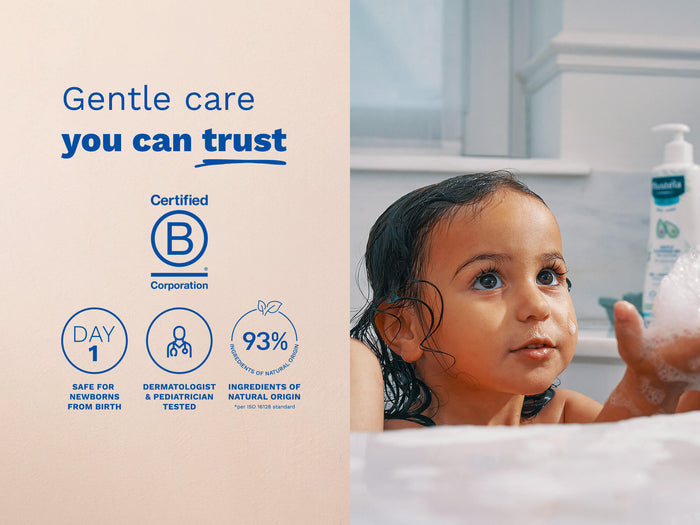 Mustela USA | Young child with wet hair playing with bubbles in the bath.
