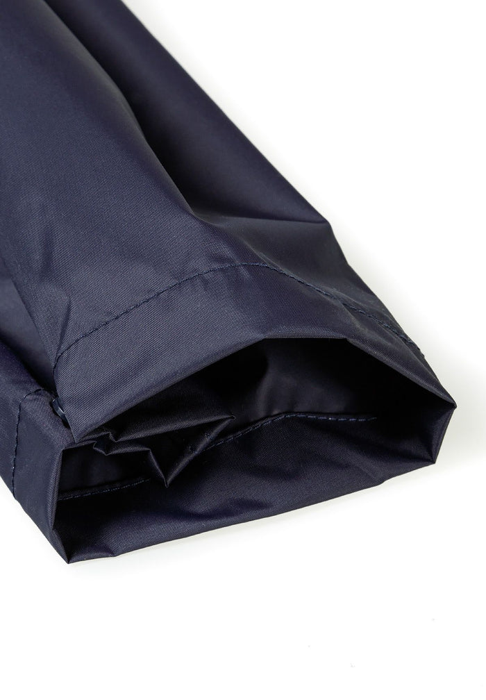 Detail of navy waterproof overpants for kids with elasticated ankle cuffs.
