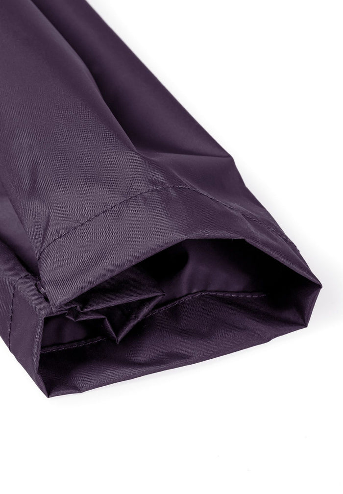 Detail of purple waterproof overpants with elasticated cuffs.