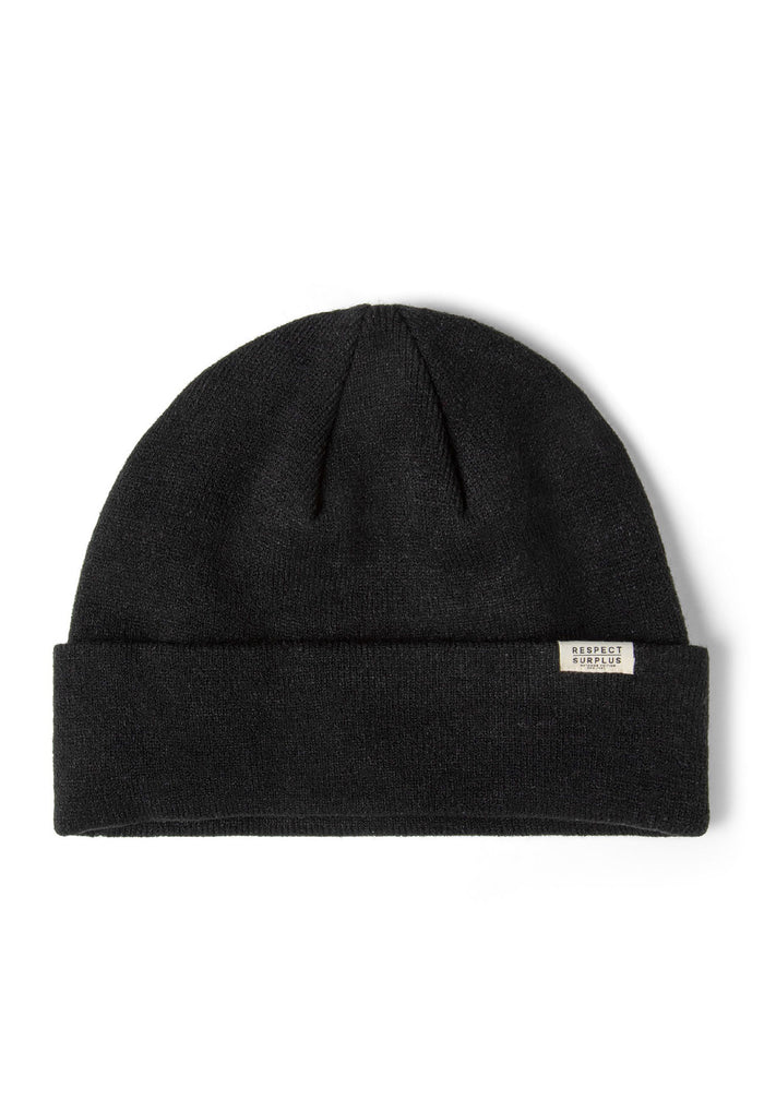 Close-up of a black ribbed beanie hat with a fold-up cuff and a discreet badge.