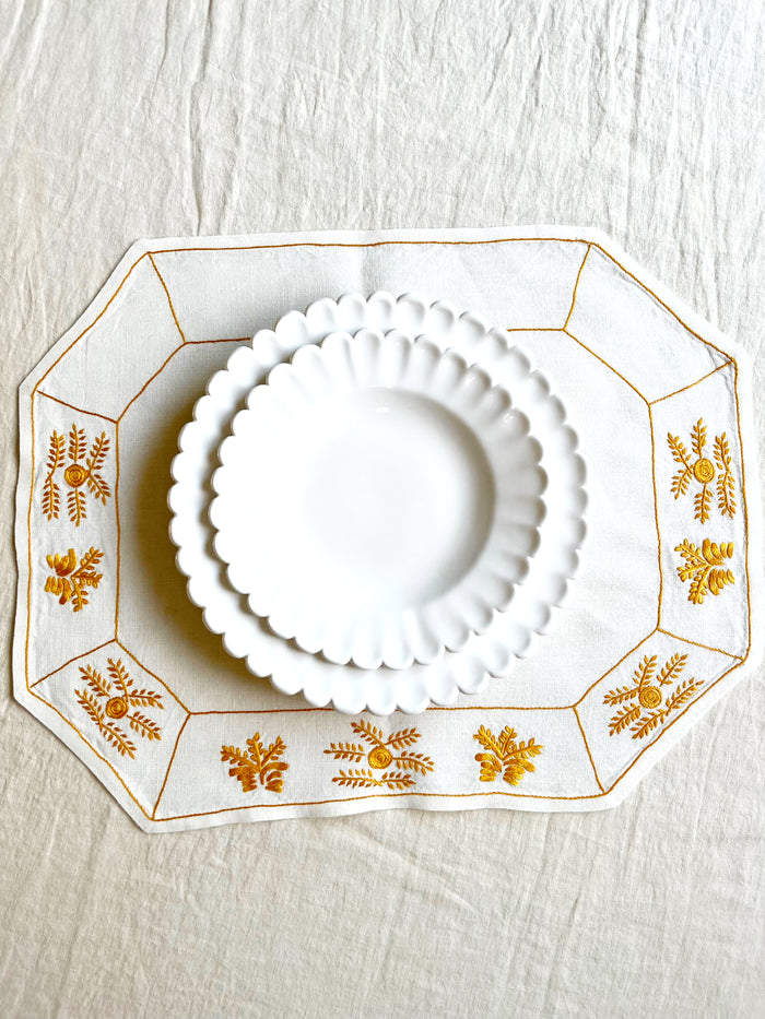octagonal white linen placemat with gold embroidery 19.5" by 16" with placesetting