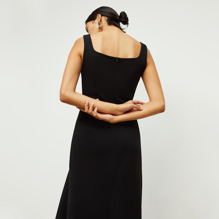 Back image of a woman standing wearing the james dress in black
