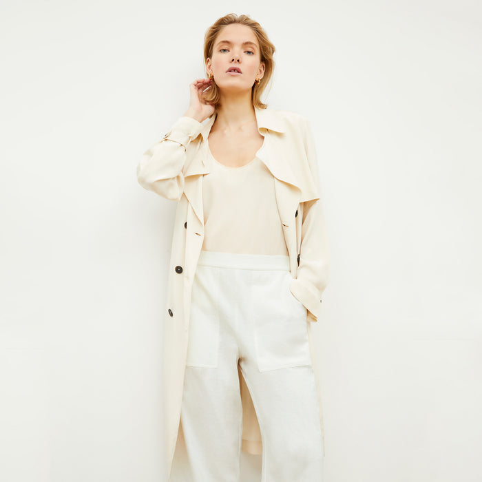Front image of a woman standing wearing the Jensen Trench—SustainSilk in Pearl