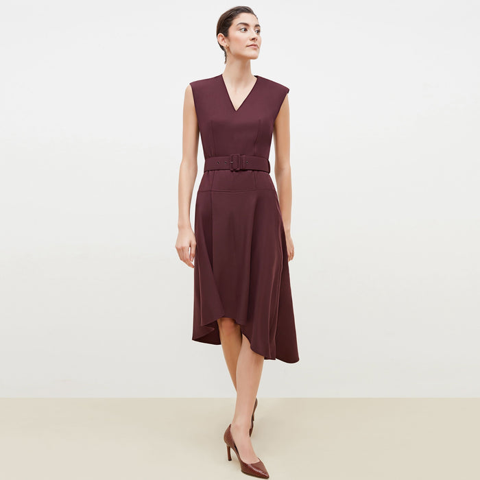 Front image of a woman standing wearing the Kelsey Dress-Sharkskin in garnet