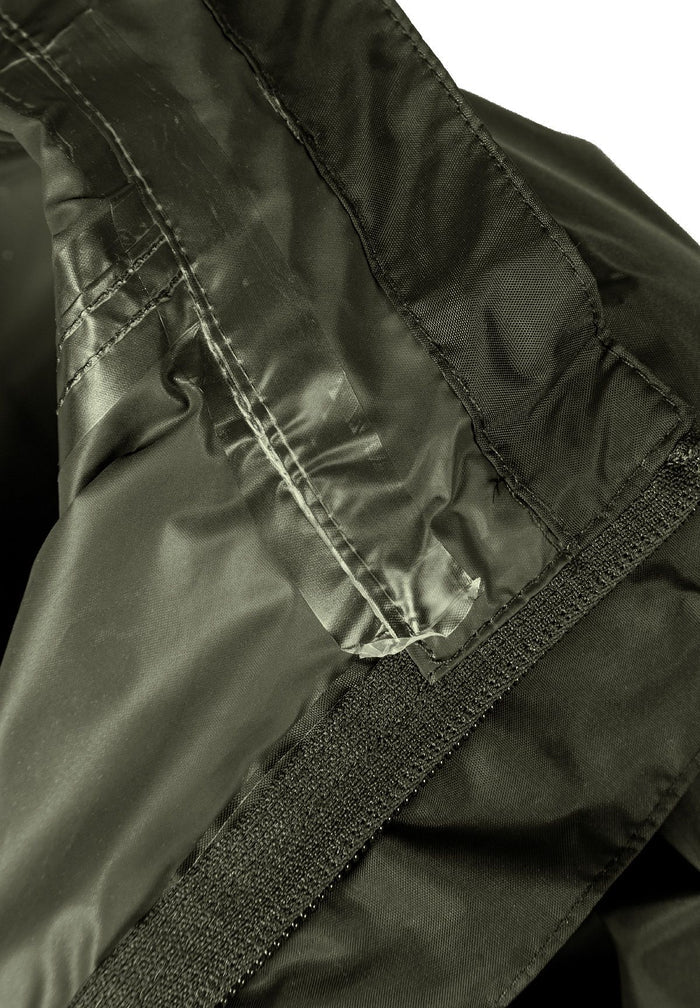 Detail of a khaki kids waterproof jacket showing the interior seam and velcro.