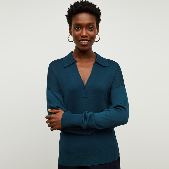 Front image of a woman standing wearing the leo top in deep sea