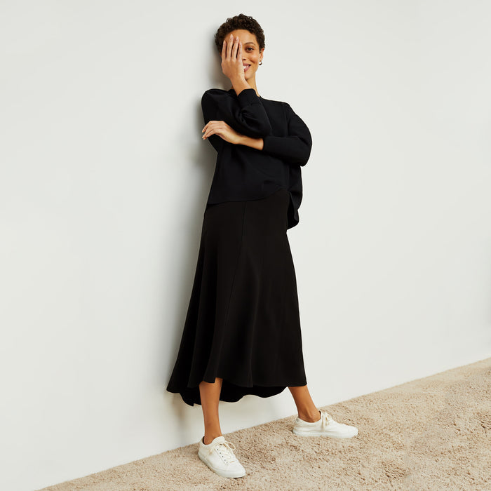 Front image of a woman standing wearing the Melrose Skirt in Black
