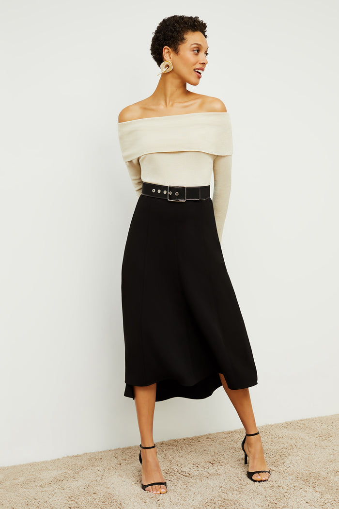 Front image of a woman standing wearing the Melrose Skirt in Black | Grid | Exclude
