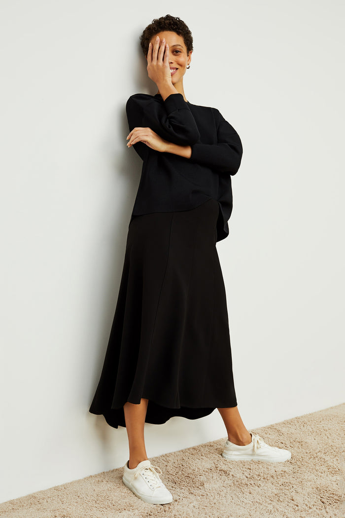Front image of a woman standing wearing the Melrose Skirt in Black | Grid Hover | Exclude
