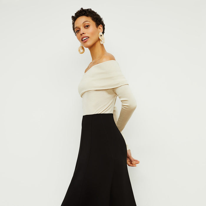Side image of a woman standing wearing the Melrose Skirt in Black | Exclude
