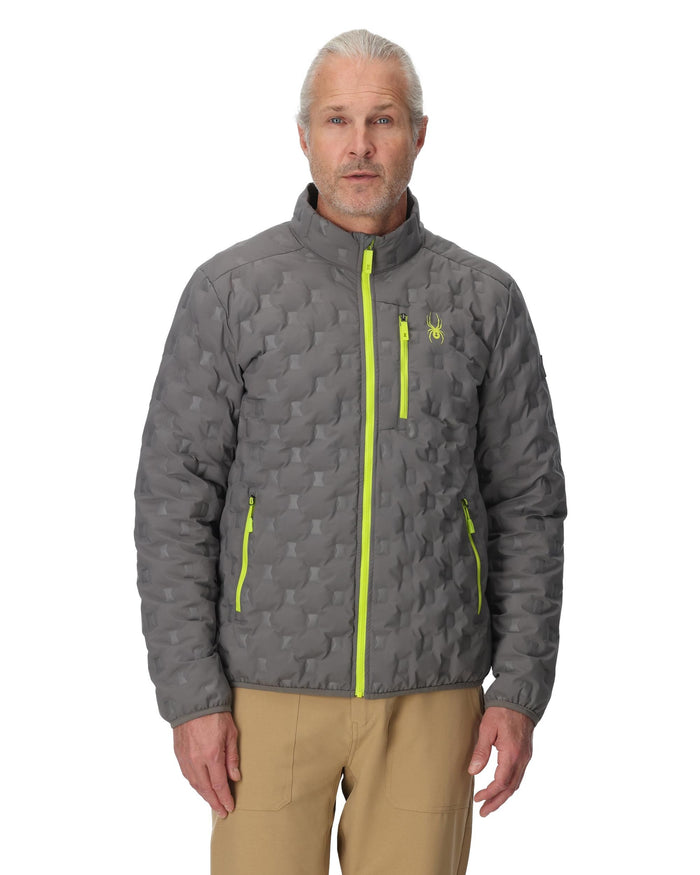 Man wearing a gray quilted jacket with yellow zippers on a white background