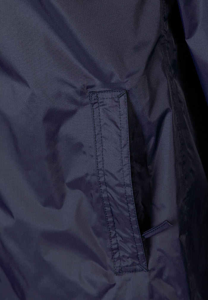 Detail of navy waterproof jacket showing zipped pocket.