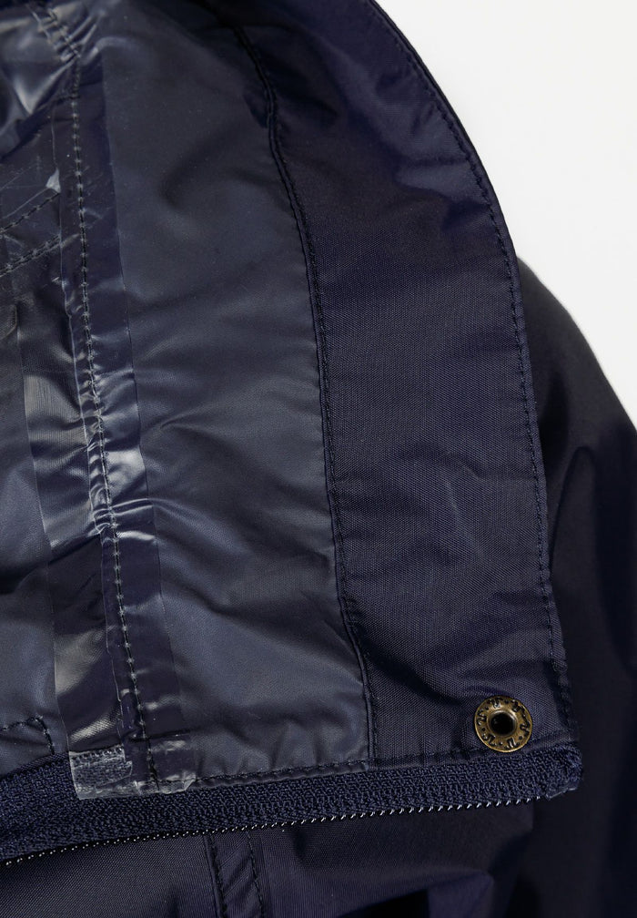 Detail of navy waterproof jacket showing concealed hood and zip fastening.