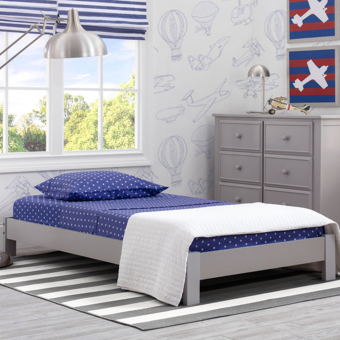 A Platform Twin Bed with a grey headboard and white and blue bedding in a child's room with decorative wall decals.