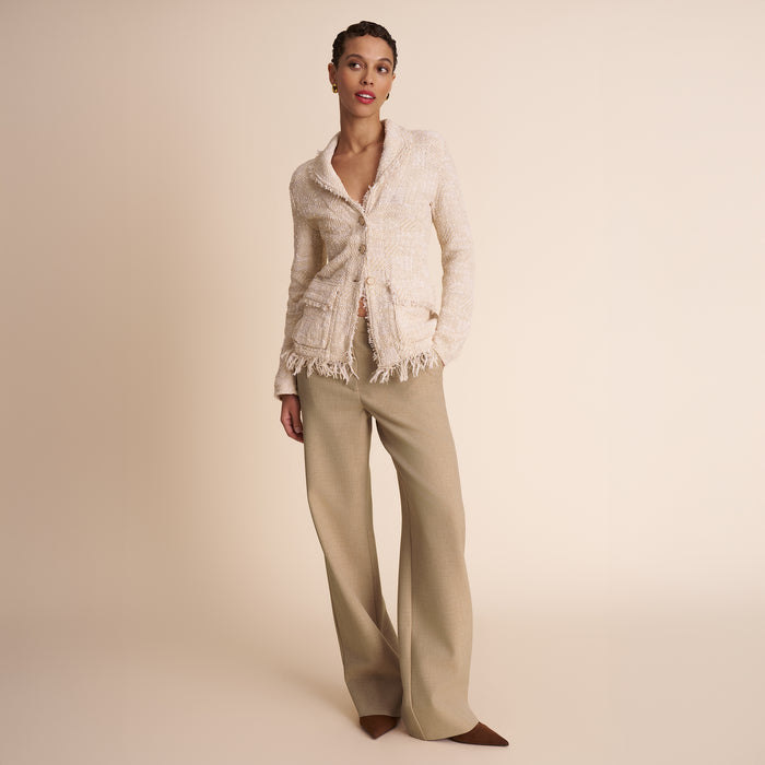 Woman wearing a beige jacket and pants on a beige background
