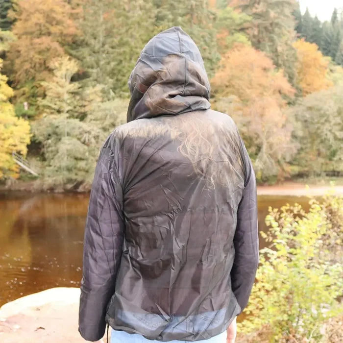 Lifestyle image of a Pyramid midge jacket being worn by a woman outdoors by a river shown from the back