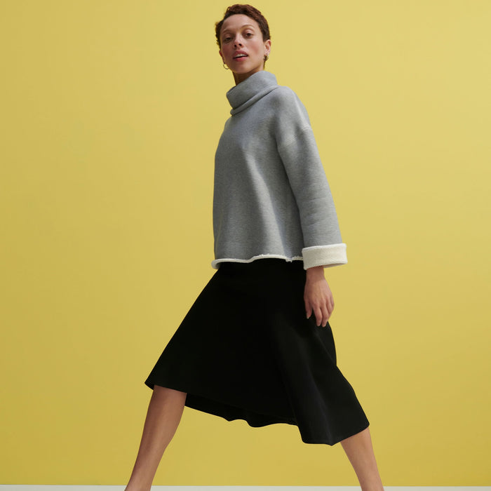 Side image of a woman standing wearing the Sharon Top—Plush Terry in Gray / Ivory