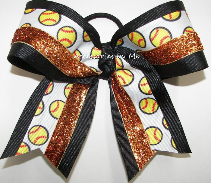 A cheer bow featuring a white grosgrain ribbon printed with yellow and red softball patterns, accented with black grosgrain ribbon and metallic orange copper glitter ribbon, tied into a large bow on a white background.