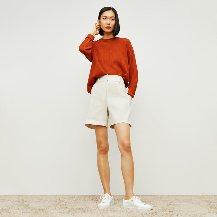 Front image of a woman standing wearing the tyler sweatshirt in canyon