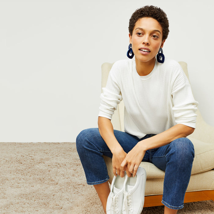 Front image of a woman standing wearing the tyler sweatshirt in ivory