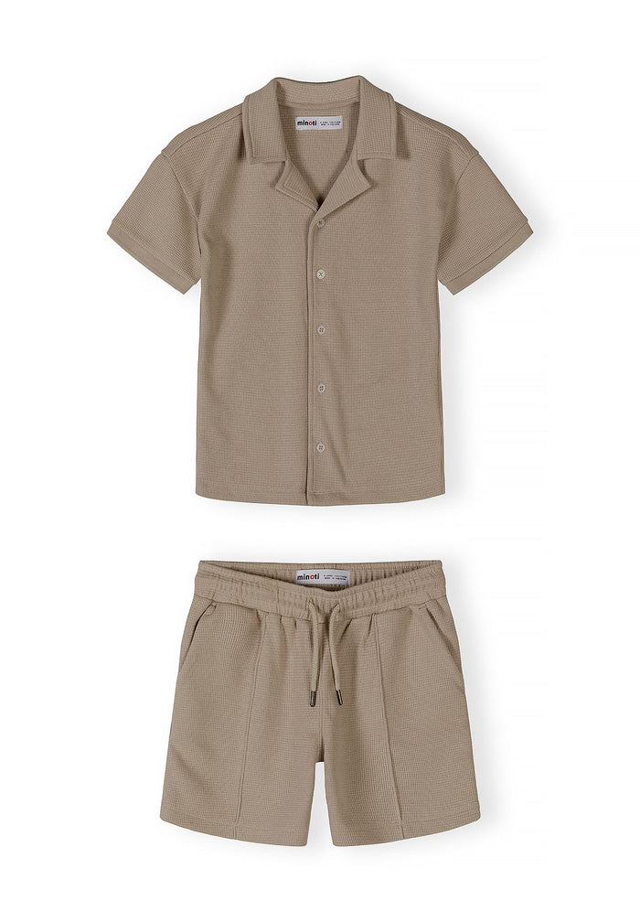 Boys cotton polo shirt and shorts set in muted sand, front view with button placket and elasticated waistband.