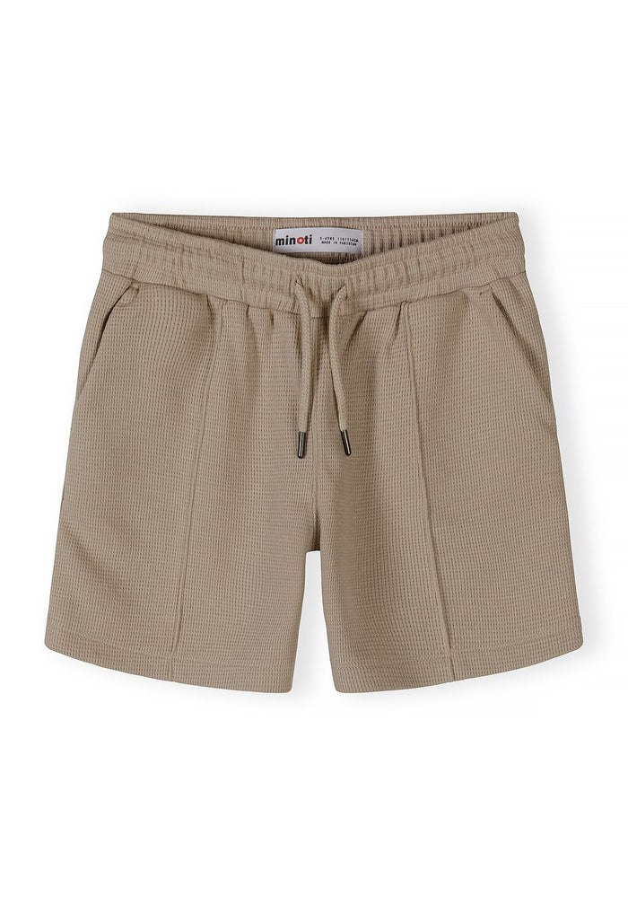 Detail of boys' shorts with elasticated waistband and side pockets in muted sand.
