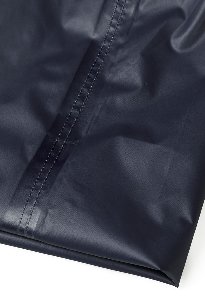 Detail of navy waterproof overpants with smooth finish and stitching.