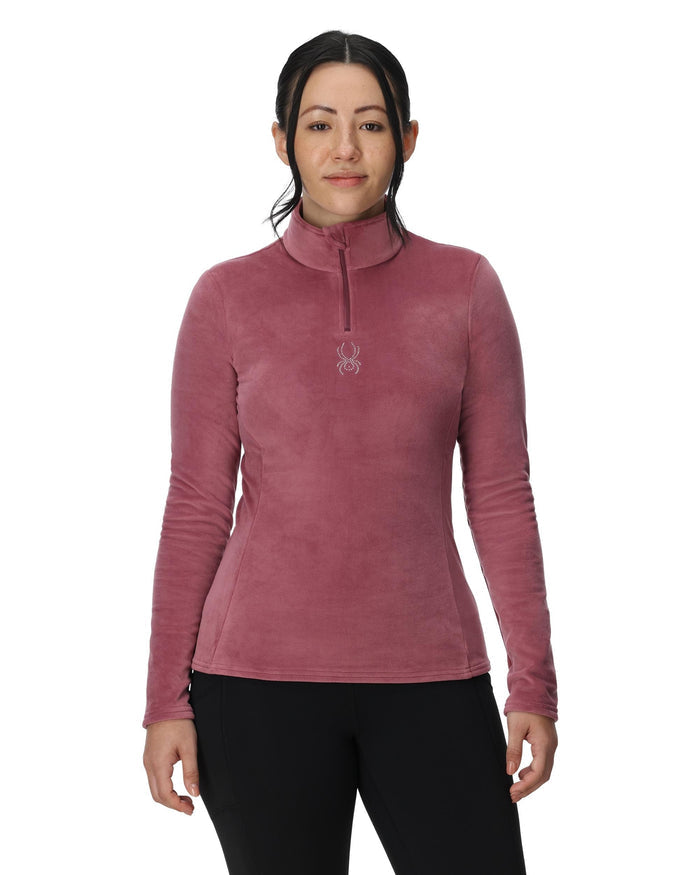 Woman wearing a pink long-sleeve shirt with a brand logo on a white background