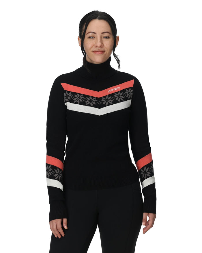 Person wearing a black turtleneck sweater with red and white pattern on a white background