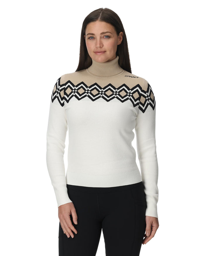 Woman wearing a white sweater with black geometric patterns on a white background