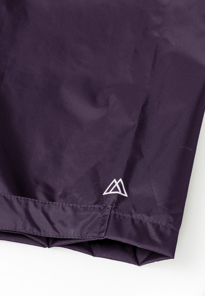 Close-up of purple waterproof overpants with adjustable cuffs and logo.