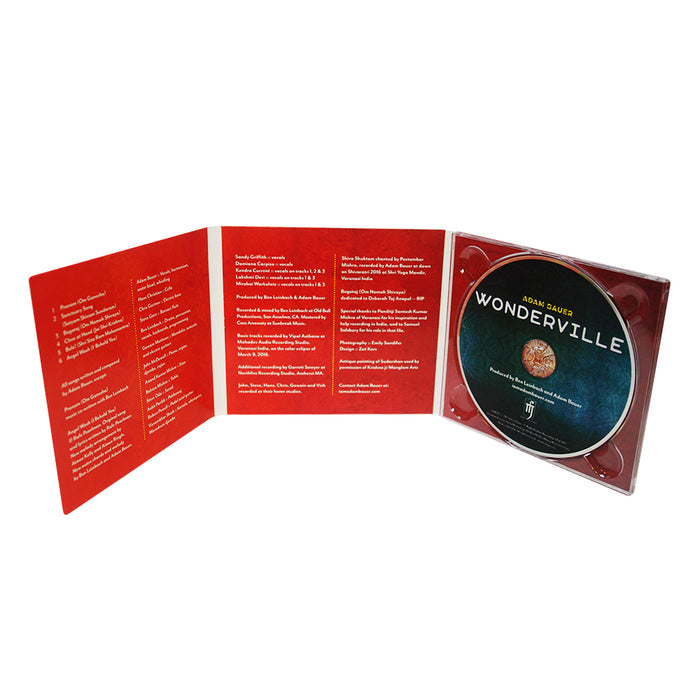 An open red CD case shows the Adam Bauer Wonderville CD on the right, with song lyrics or credits—including “Om Namah Shivaya”—printed on the inside left and center panels.